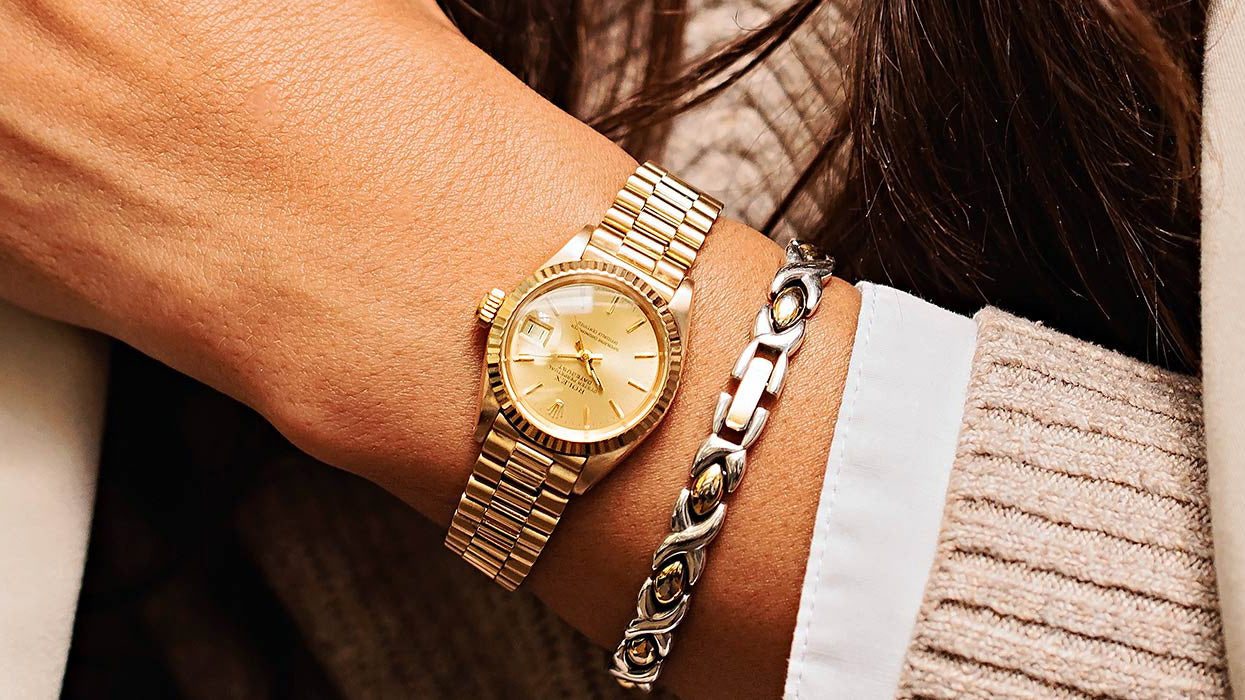 A curated selection of luxury watches suitable as a gift, including Cartier Tank and Rolex Oyster Perpetual references