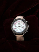Omega Speedmaster Automatic Chronograph 38mm Ref. 3834.74.34 – angled top view, white mother-of-pearl dial, pink leather strap, dark background