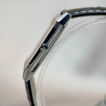 Jaeger-LeCoultre Reverso top profile close-up showing polished stainless steel case edge, crown and black leather strap on white background