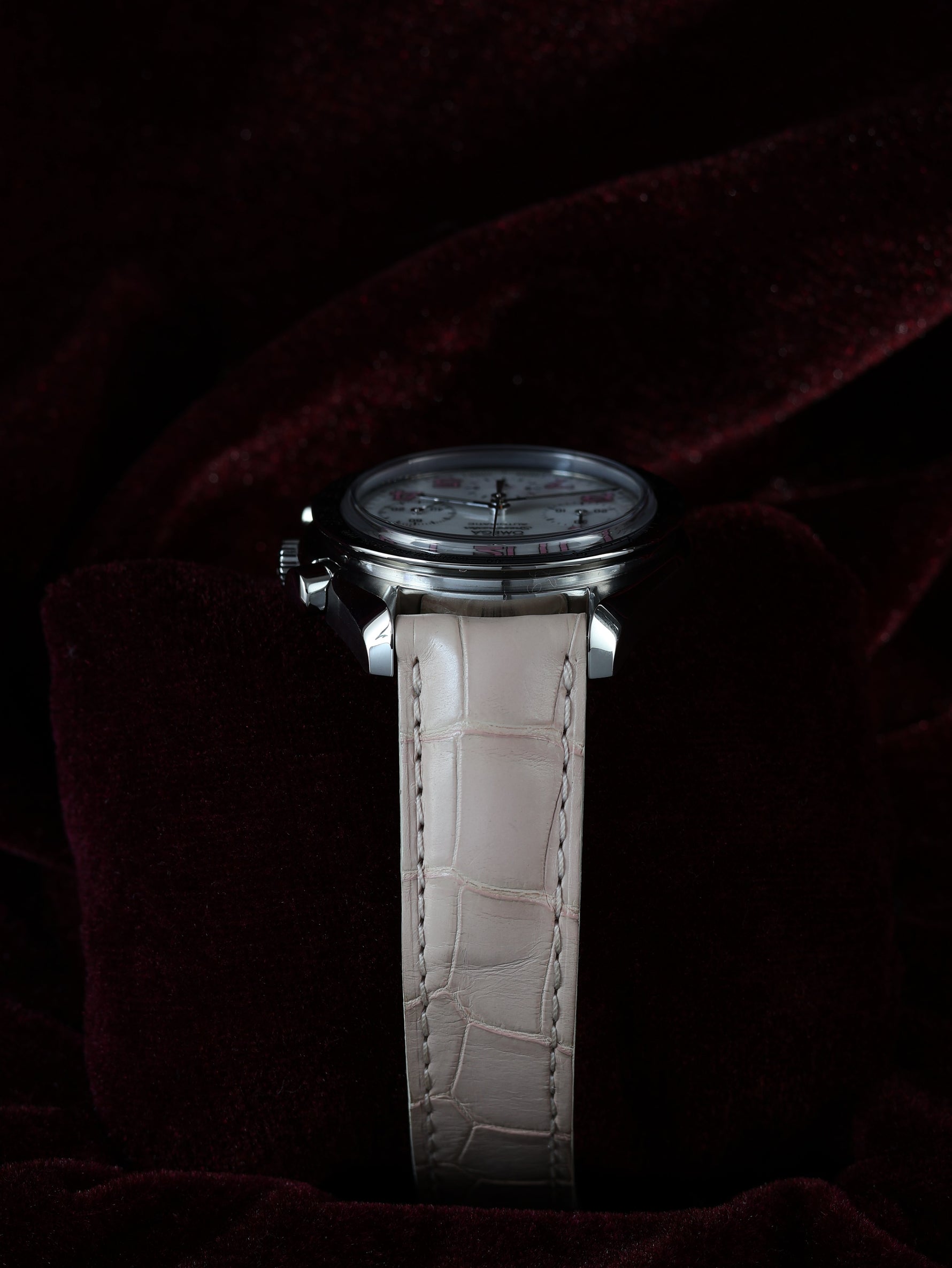 Omega Speedmaster Automatic Chronograph 38mm Ref. 3834.74.34 – left profile view, back case side with pushers, pink leather strap, dark background