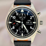 IWC watch with black dial and leather strap on a blurred background