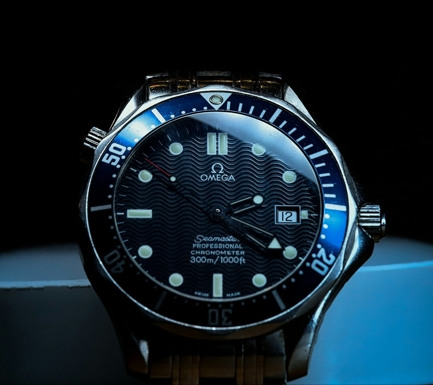 Omega watch with blue face and dark background